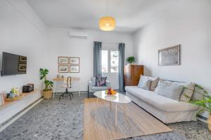 a living room with a white couch and a table at Sea,City & Mountain View Apartment in Chania Town