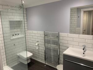 a bathroom with a toilet and a sink and a shower at Flat One, 212 Eaglesham Road, East Kilbride, Glasgow in Glasgow +6 photos