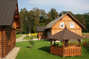 a wooden house with a gazebo in the yard at Dom gościnny w Bartniku in StrÃ³Å¼e