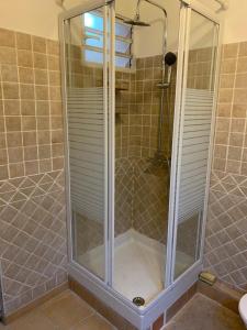a shower with a glass door in a bathroom at logement entier vue sur mer in Gourbeyre