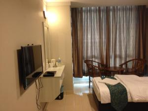 a hotel room with a bed and a tv in a room at AERO Star Hotel in Seremban