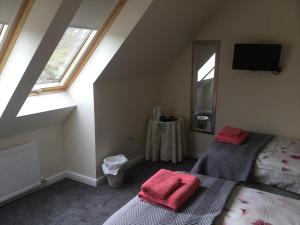 a attic bedroom with two beds and a mirror at Rhenetra in Arisaig
