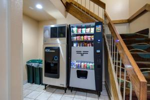 Un distributeur automatique de boissons est installé à côté d'un escalier. dans l'établissement Econo Lodge Painted Post - Corning, à Painted Post