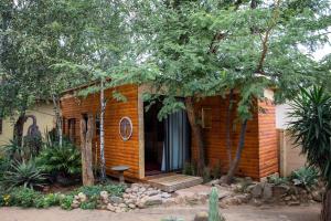 ein kleines Backsteinhaus mit einer Veranda und einer Bank in der Unterkunft Blyde Africa- Cottage in Benoni