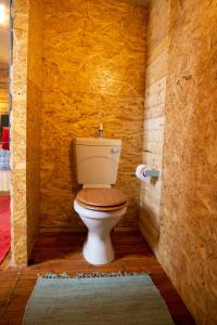 a bathroom with a toilet in a wooden wall at Blyde Africa- Cottage in Benoni