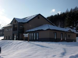 budynek ze znakiem w śniegu w obiekcie Pension and Restaurant La Collina w mieście Nakafurano