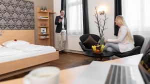 a man and a woman in a hotel room at campuszwei - Hotel & Boardinghouse in Ludwigsburg