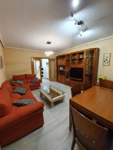 sala de estar con sofá y mesa en piso de tres dormitorios con garaje y todos los servicios cerca, en Burgos