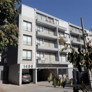 un edificio de apartamentos con un coche aparcado delante de él en Apart Hotel Viva Providencia en Santiago