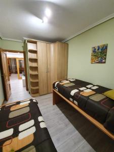 1 dormitorio con 2 camas y armario en piso de tres dormitorios con garaje y todos los servicios cerca, en Burgos