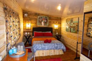 1 dormitorio con 1 cama en una cabaña de madera en Blyde Africa- Cottage en Benoni