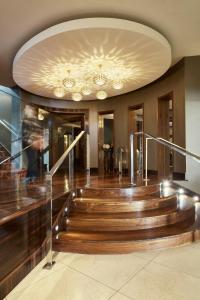 a lobby with wooden stairs and a ceiling with chandeliers at Killarney Towers Hotel & Leisure Centre in Killarney