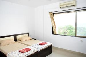 1 dormitorio con 2 camas y ventana en 3 BHK Apartment with river view, en Panaji