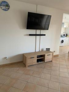 a living room with a flat screen tv on a cabinet at logement entier vue sur mer in Gourbeyre