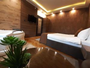 a hotel room with a bed and a sink at Stan na Dan Apartman D Lux Jacuzzi in Kragujevac