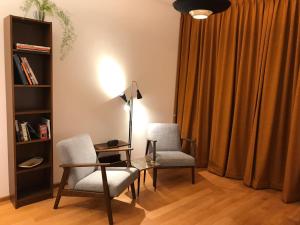 ein Wohnzimmer mit 2 Stühlen, einem Schreibtisch und einer Lampe in der Unterkunft Huis nummer 1 in Eindhoven