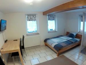 - une chambre avec un lit, un bureau et des fenêtres dans l'établissement Ferienzimmer Gersprenztal, à Reichelsheim