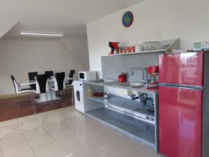 a kitchen with a red refrigerator and a sink at T3 (130m²) Hypercentre St-Denis, vue sur mer et montagne in Saint-Denis