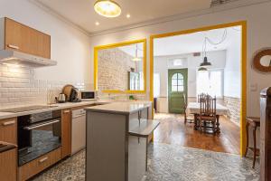 a kitchen with a counter and a dining room at La maison des couturières in Cluny +24 photos