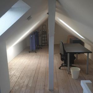 ein Büro im Dachgeschoss mit einem Schreibtisch und einem Tisch in der Unterkunft 45 m² Maisonette-Wohnung in Uni-/Hauptbahnhofnähe in Duisburg