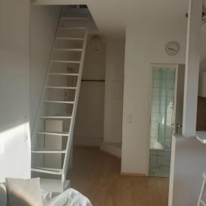 45 m² Maisonette-Wohnung in Uni-/Hauptbahnhofnähe في دويسبورغ: درج حلزوني أبيض في غرفة بيضاء