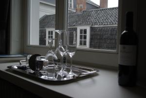 a tray with wine glasses on a counter with a window at B&B Huyze Weyne in Bruges