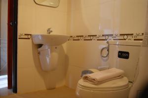 La salle de bains est pourvue de toilettes blanches et d'un lavabo. dans l'établissement The City House, à Krabi