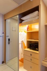 a walk in closet with a sliding glass door at Hotel Solo, Sukhumvit 2, Bangkok - SHA Extra Plus in Bangkok