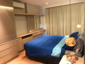 a bedroom with a large blue bed and a table at Asoke Bts Mrt Bangkok New Luxury Room in Bangkok