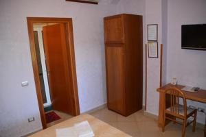 a room with a desk and a wooden cabinet at Affittacamere Stranamore in Frascati