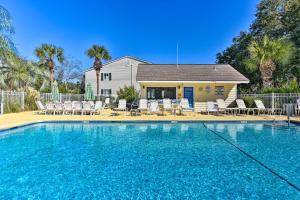 a swimming pool in front of a house at St Simons Condo with Resort Amenities 1 Mi to Beach in Mallory Park