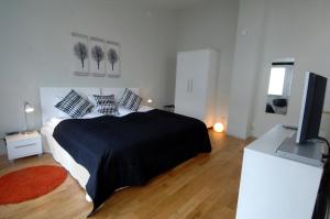 a bedroom with a bed and a flat screen tv at Forenom Serviced Apartments Goteborg A-R Lorents Gata in Gothenburg