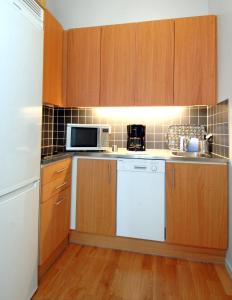 uma cozinha com um frigorífico branco e um micro-ondas em Forenom Serviced Apartments Goteborg A-R Lorents Gata em Gotemburgo