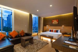 a hotel room with a bed and a couch at Hotel Solo, Sukhumvit 2, Bangkok - SHA Extra Plus in Bangkok