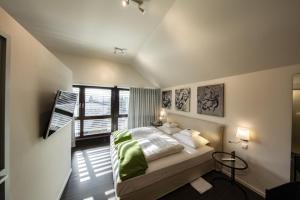 a bedroom with a bed and a large window at Mintrops Land Hotel Burgaltendorf in Essen