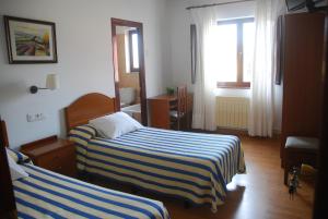 ein Hotelzimmer mit zwei Betten und einem Fenster in der Unterkunft HOTEL CARAVIA in Caravia + 10 Fotos