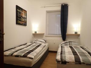 zwei Einzelbetten in einem Zimmer mit Fenster in der Unterkunft Meine Ferienwohnung Seeburg 2 in Seeburg
