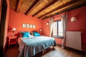 a bedroom with orange walls and a bed with blue sheets at Foresteria Borgoluce in Susegana