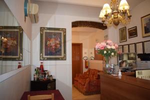 a living room with a couch and a vase of flowers at Hotel Dalmazia in Florence