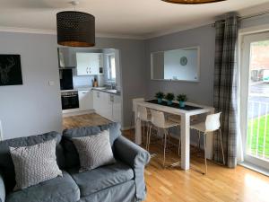 uma sala de estar com um sofá e uma mesa em Flat Five, 212 Eaglesham Road, East Kilbride, Glasgow em East Kilbride