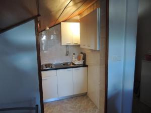 a small kitchen with white cabinets and a sink at Apartments Suljic in Stari Grad