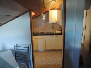 a small kitchen with white cabinets and a table at Apartments Suljic in Stari Grad