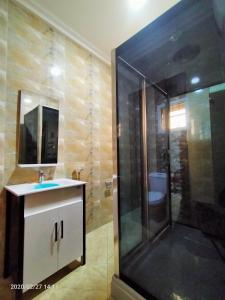 La salle de bains est pourvue d'une douche et d'un lavabo. dans l'établissement Alim Royal Hotel and Suite, à Abuja