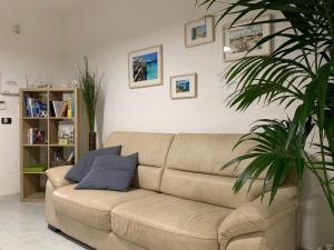 トッレ・デル・オルソにあるVilla Zenの植物のあるリビングルームの茶色のソファ