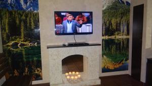 una chimenea con TV encima en Hotel Verona, en Novokuznetsk