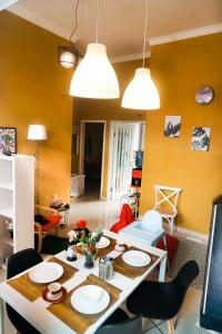 a living room with a table and chairs and yellow walls at Tropical Boutique Batu Villa, Near Museum Angkut in Batu