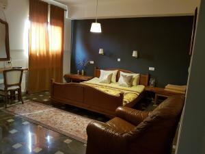 a bedroom with a bed and a leather couch at Hostel Mornar in Velika Kladuša