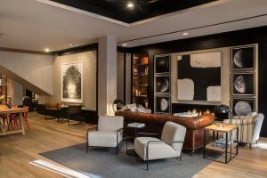a living room with a leather couch and chairs at Casa Elliot Hotel in Barcelona