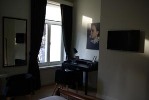 B&B Huyze Weyne في بروج: غرفة بها مكتب ومرآة ومغسلة