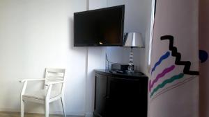a room with a tv and a chair and a desk at Le LAZARET in Marseille
